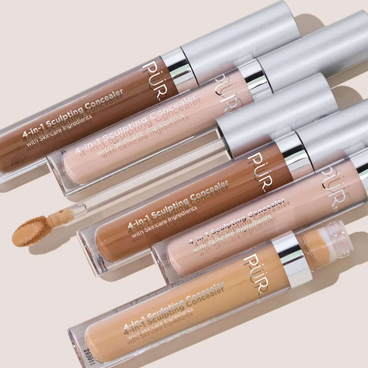 4-in-1 Sculpting Concealer Several Shades aligned against beige background