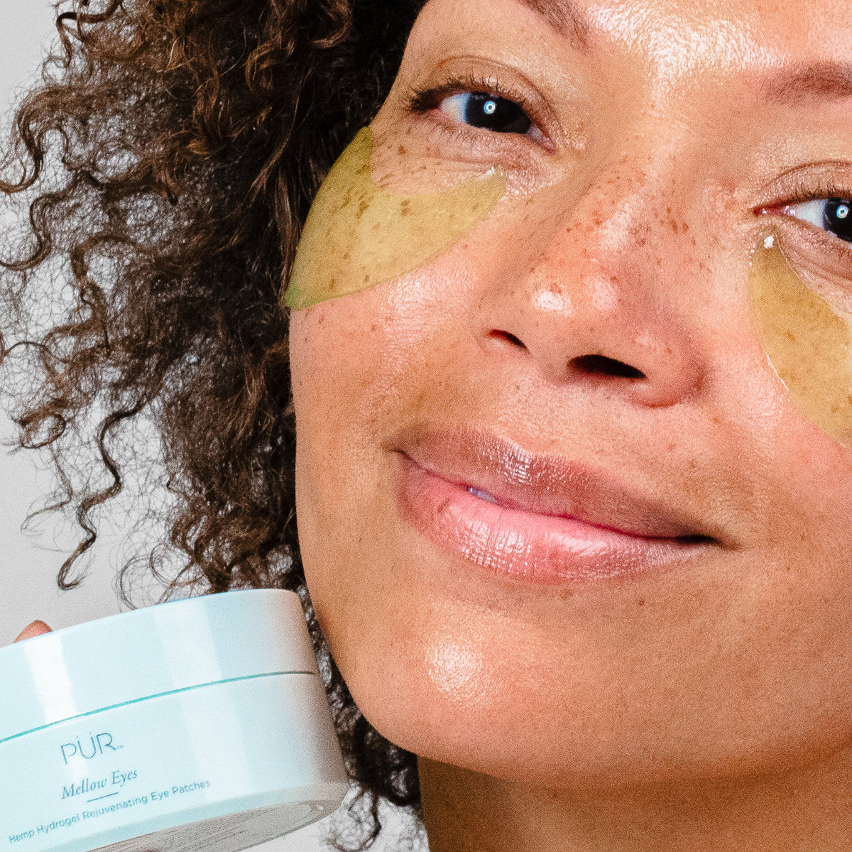Mellow Eyes in Hemp - Woman wearing eye patches while holding the product silo 